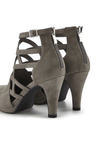 Graue Wildleder-Pumps mit einem Cut-Out-Design, Knöchelriemen mit Schnalle und Reißverschluss hinten. Strukturierte Oberfläche mit glatten Akzenten.