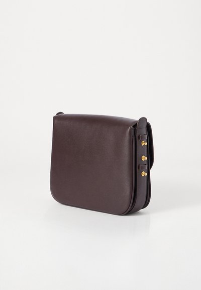 Borsa a spalla in pelle marrone scuro con una texture liscia, bordi arrotondati e dettagli in metallo dorato sulla tracolla.