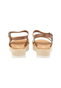 Sandalias marrones con tiras que presentan una plataforma de estilo alpargata texturizada, una plantilla suave y detalles metálicos en las hebillas de las correas del tobillo.