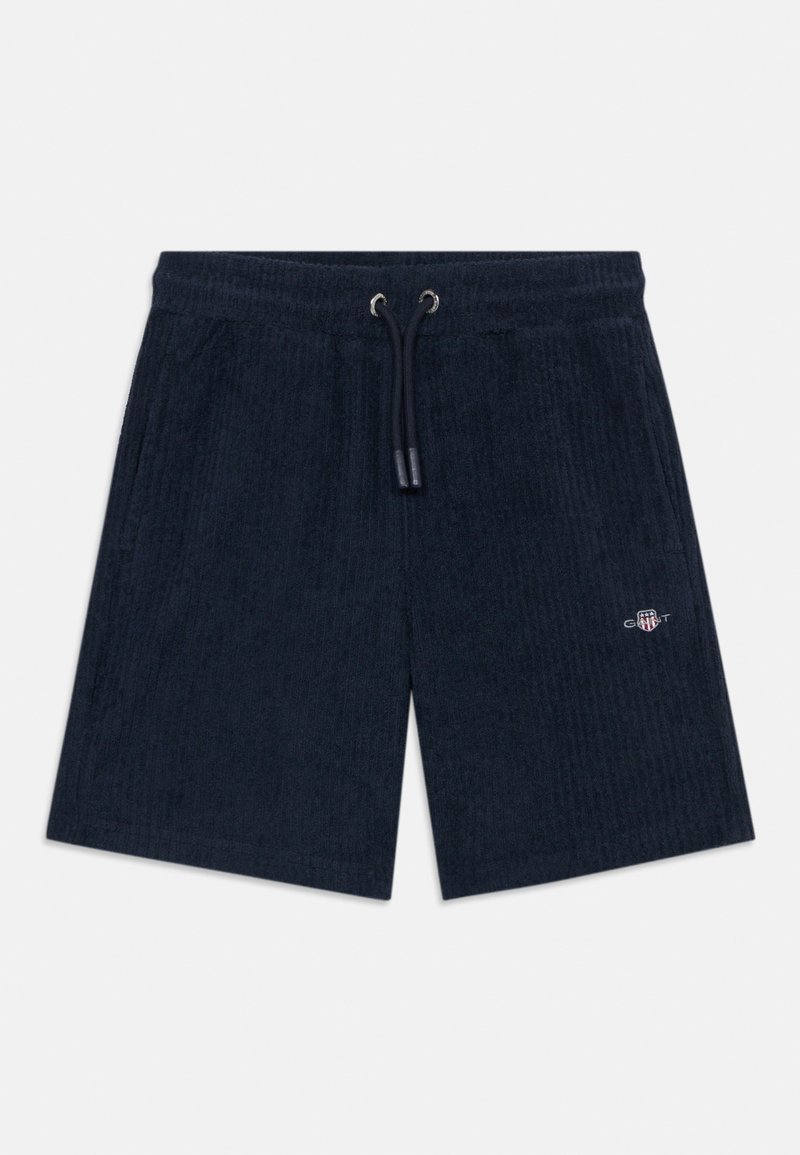 Μαρινί βερμούδα από πετσετέ ύφασμα με ελαστική μέση, κορδόνι, πλαϊνές τσέπες και μικρό κεντητό λογότυπο GANT στο αριστερό πόδι.