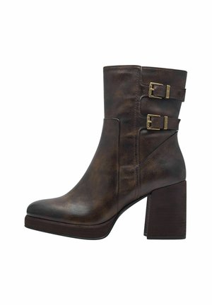 Bottines en cuir marron avec deux accents de boucle, un bout rond et un talon épais. Fini texturé avec une surface lisse.