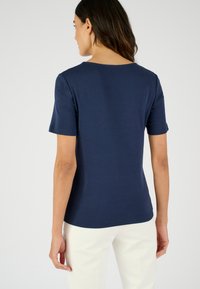 T-shirt blu navy a maniche corte con scollatura rotonda, realizzato in un tessuto morbido e liscio. Presenta una vestibilità dritta e dettagli di cucitura minimi.