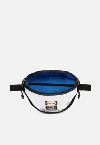 Borsa in tessuto bianco e nero con interno blu, dotata di chiusura con zip e tracolla regolabile; presenta un'etichetta con il marchio Eastpak sul davanti.