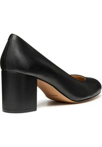 Svart lädersko med rund tå och bred, klossaktig klack. Slät textur med minimal design och utskärning vid tån.