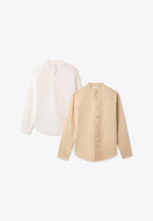 Due camicie a maniche lunghe, una bianca e una beige, con colli rotondi e chiusure con bottoni frontali. Entrambe presentano un tessuto liscio e leggero.