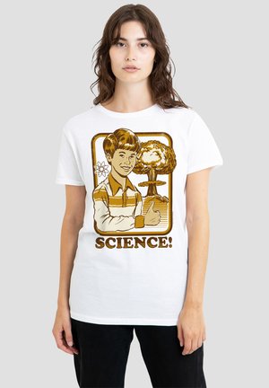 Junge Person trägt weißes Hemd mit Retro-Illustration eines Jungen, der neben einer Pilzwolke und einem Atomsymbol den Daumen hoch zeigt, Text "WISSENSCHAFT!"