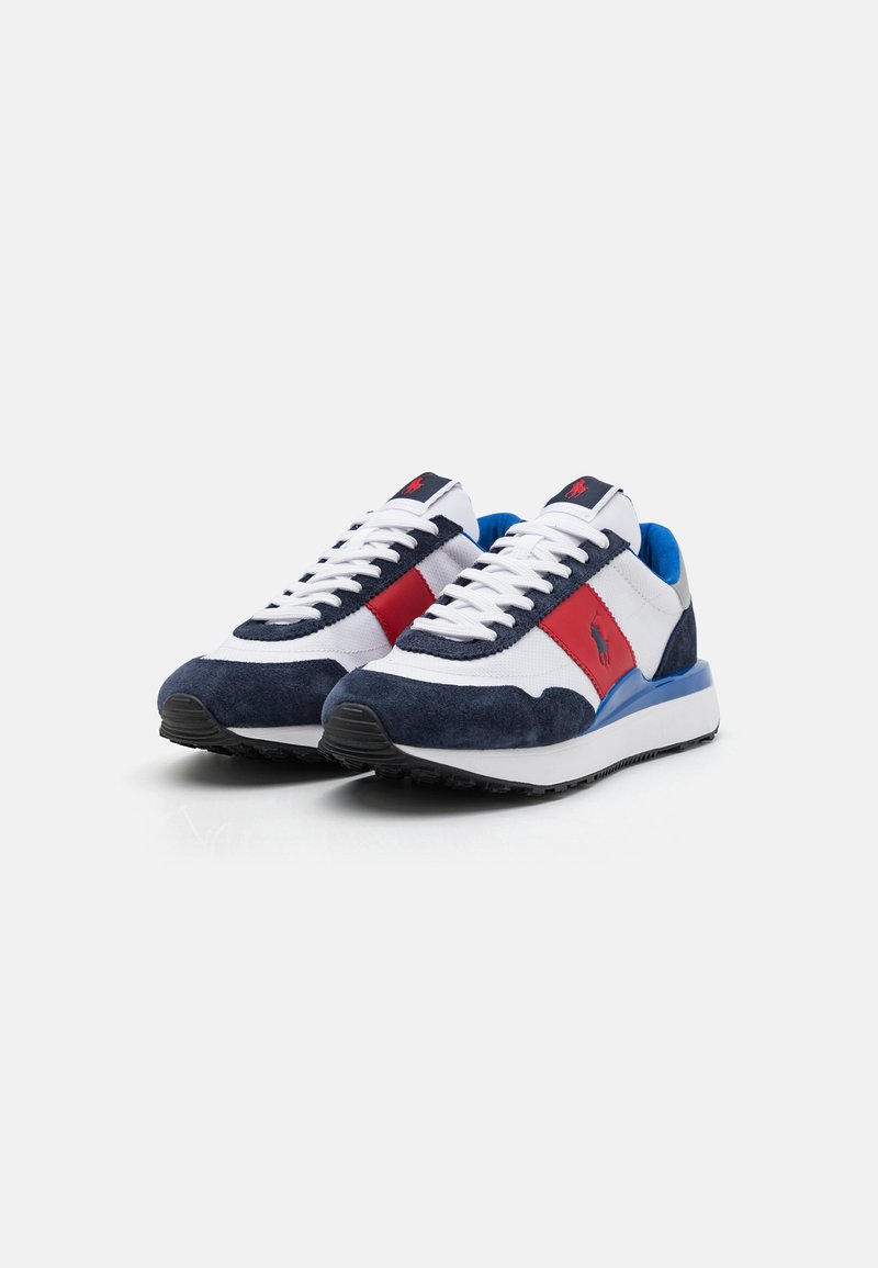 Zapatillas con parte superior de malla blanca, detalles en ante azul marino, acentos rojos y azules, y suela de goma negra. Presentan cordones blancos y un logo.