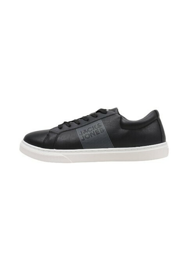 Zapatilla de cuero negra con suela de goma blanca, que presenta un diseño de raya texturizada en el costado y cordones negros. Forma simple y moderna.