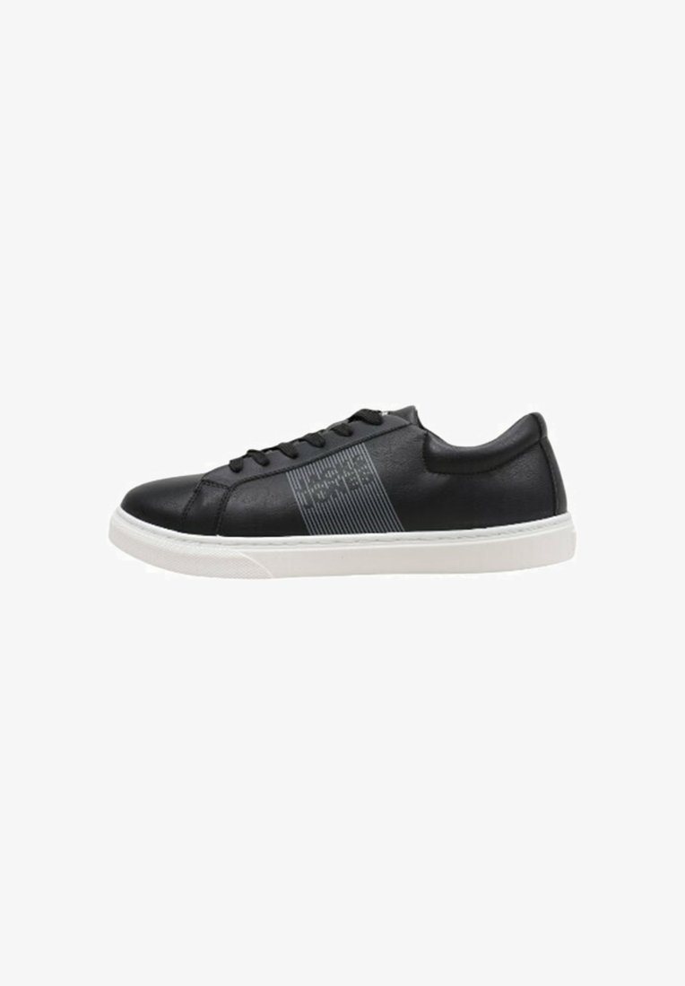 Zapatilla de cuero negra con suela de goma blanca, que presenta un diseño de raya texturizada en el costado y cordones negros. Forma simple y moderna.