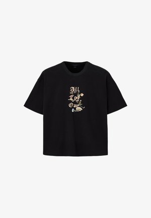 Czarny t-shirt z krótkim rękawem, z kwiatowym wzorem i napisem "All For One" w beżowej, gotyckiej czcionce, umieszczony centralnie na przodzie.