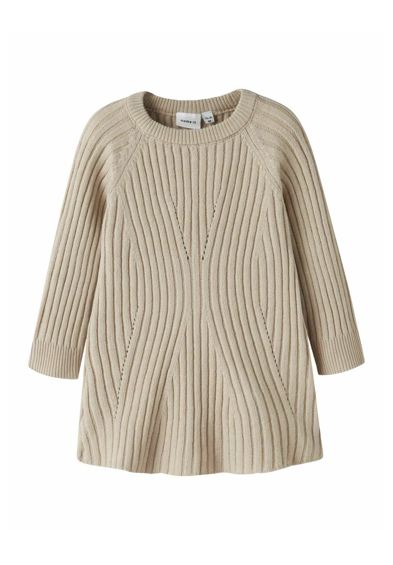 Pull en tricot beige avec une texture côtelée, un col rond, des manches trois quarts et un corps évasé avec des lignes décoratives.