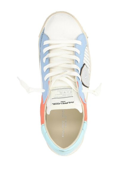 Sneaker bianco con accenti blu, corallo e azzurro chiaro. Presenta lacci piatti, un pannello laterale testurizzato e un logo del marchio visibile sulla linguetta.