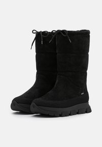 Botines de ante negro con un diseño acolchado, puntera redonda, cierre de cordones y suela de goma gruesa. Textura suave y forma aerodinámica.