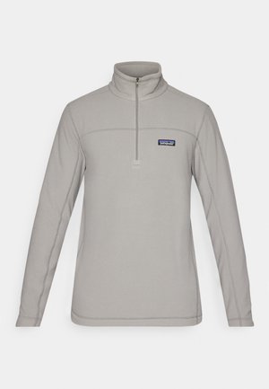 Szary polarowy sweter z wysokim kołnierzem, półzamek i kontrastowe przeszycia. Posiada małe logo na lewej piersi.