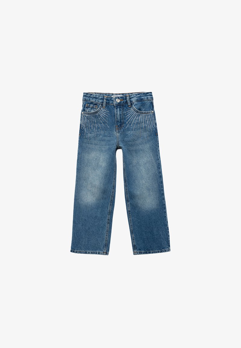 Pantalones vaqueros anchos de mezclilla en azul medio con acabado desgastado. Presenta decoloraciones y tachuelas metálicas decorativas dispuestas en un patrón radial.