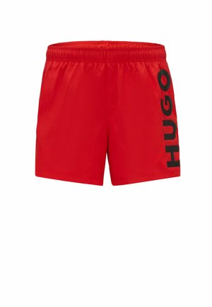 Rote Badehose mit elastischem Bund, mit einem großen schwarzen "HUGO"-Logo, das vertikal auf der linken Seite bedruckt ist. Aus leichtem Material gefertigt.