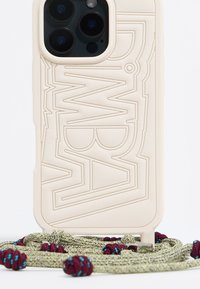Custodia per telefono di un beige chiaro con design in rilievo, adatta a tre obiettivi della fotocamera, accompagnata da una tracolla intrecciata verde e viola dalla texture. 