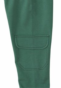Grüne Baumwollmischungshose mit einer großen aufgesetzten Tasche und kontrastierenden Nähten. Gleiche Struktur und enganliegendes Design.
