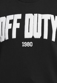 Czarny T-shirt z białymi literami o fakturze frotté, na którym widnieje napis "OFF DUTY" oraz "1980" poniżej, z okrągłym dekoltem i teksturowanym materiałem.