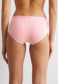 Rosa gestreifte Baumwollslips mit mittelhohem Schnitt, ausgestattet mit einem weichen Bund und einer glatten Textur, entworfen für Komfort und den täglichen Gebrauch.