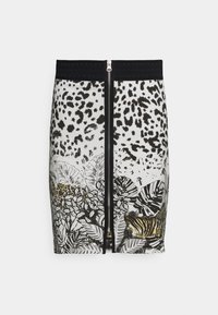 Jupe jusqu'aux genoux avec une ceinture noire, présentant un motif en tissu blanc avec des taches de léopard noires et un feuillage tropical, incluant un tigre.