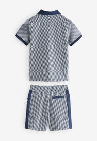 Marineblauwe en witte set van een poloshirt met korte mouwen en shorts, met een geweven honingraatpatroon, contrasterende kraag en zijaccenten, en een elastische tailleband op de shorts.