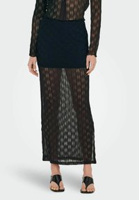 Sort maxi nederdel med gennemsigtigt, tekstureret stof, der har lodrette striber. Designet har en elastisk talje og en tætsiddende inderforing.