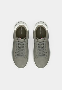 Baskets en cuir gris avec des accents blancs, bout rond et laçage traditionnel. Présentent une surface texturée et une semelle intérieure rembourrée.