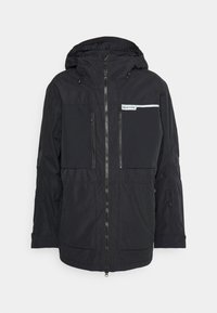 Veste noire avec fermeture éclair à l'avant et capuche, comportant deux poches poitrine zippées et un logo sur le côté gauche. Tissu léger avec une finition mate.