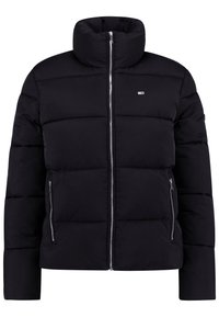 Svart puffjacka med hög krage, dragkedja fram och två sidofickor. Har quiltad struktur och en liten logotyp på bröstet.