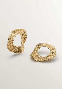 Pendientes de metal dorado con un diseño trenzado, que presentan una forma ovalada abierta y una superficie texturizada, destacando un acabado mate y un detalle intrincado.