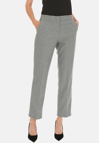 Jasnoszare dopasowane spodnie o gładkiej fakturze, prostym kroju nogawek i bocznych kieszeniach. W zestawie z czarnymi szpilkami.