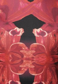 Motif floral rouge sur fond sombre, présentant de grandes pétales texturées avec un dégradé d'ombrage, créant un contraste saisissant.