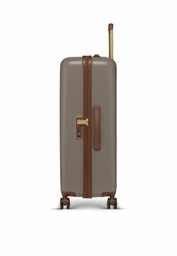 Harde koffer in een gedempt tan-kleur met een bruine rits en accenten. Beschikt over een uitschuifbaar handvat en vier wielen voor gemakkelijke manoeuvreerbaarheid.