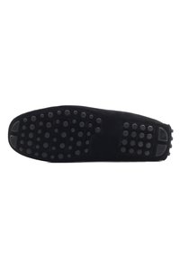 Schwarze Schuhsohle mit strukturierter Oberfläche und runden Noppen. Der Rand ist glatt mit leichter Krümmung. Wildledermaterial ohne sichtbare Markierungen.