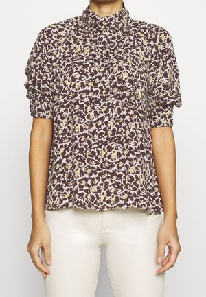 Braune Bluse mit floralen Mustern, Rüschensaum am hohen Kragen und kurzen Ärmeln. Verfügt über ein texturiertes Druckbild mit cremefarbenen und gelben Blumenmustern.
