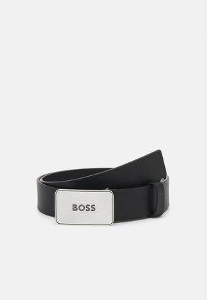 Schwarzer Ledergürtel, zusammengerollt, mit einer rechteckigen silbernen Schnalle, auf der das Wort "BOSS" in Großbuchstaben geprägt ist.