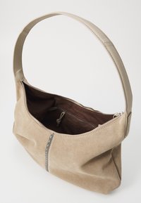 Beige mokkanahka handbag, jossa on sileä nahkahihna, vetoketjusuljenta ja sisäpuolella vetoketjutasku. Korostavana yksityiskohtana on eriväriset ompeleet sauman varrella.