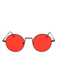 Lunettes de soleil rondes avec des verres rouges, monture en métal noir, branches fines et un design minimaliste. Plaquettes de nez transparentes pour le confort.