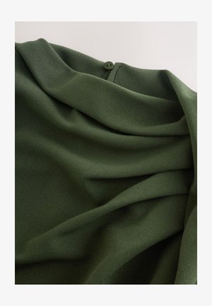 Dark green, soft fabric with subtle draping and a button detail at the neckline; smooth texture and fluid design.