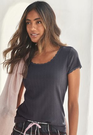 Dark gray ribbed short-sleeve top with scalloped neckline, paired with a light pink cardigan. Textured fabric with visible patterns.