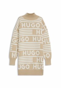 Beige neulepaita, jossa on valkoinen "HUGO"-logokuvio, korkea kaulus ja löysä istuvuus, ribbauslaitaiset hihansuut ja helma.