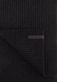 Zwarte gebreide sjaal met ribbelstructuur, met een gevouwen hoek waarop een rechthoekig zwart label is gedrukt met de tekst "JOOP! JEANS."