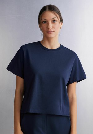 Donkerblauwe katoenen t-shirt met korte mouwen, ronde hals en een relaxte pasvorm, met een zachte textuur en zonder zichtbare patronen of accenten.