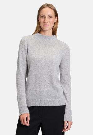 Light gray knit sweater with a crew neckline and ribbed cuffs. Soft texture and fitted silhouette, paired with dark cropped pants.