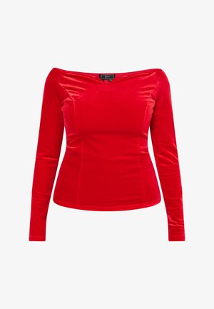 Top de terciopelo rojo de manga larga con diseño caído sobre los hombros, forma ajustada, textura suave y ligero brillo. Sin piezas metálicas visibles.