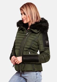 Giacca invernale in verde scuro con cappuccio in pelliccia sintetica nera. Presenta dettagli a coste neri sulle maniche, chiusura zip frontale e tasche laterali.