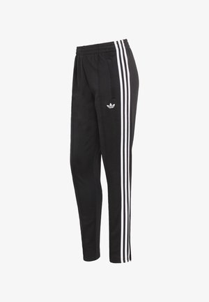 Svarta träningsbyxor med tre vertikala vita ränder på varje sida och en emblem på vänster höft. Elastisk midjeband, avsmalnande passform.