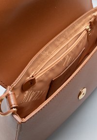 Borsa a mano in pelle marrone con esterno liscio, tasca interna con cerniera e chiusura a scatto color oro. Foderata con tessuto brandizzato.