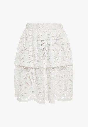 Fehér csipkés szoknya réteges kialakítással, bonyolult virágmintákkal és texturált felülettel. Könnyű és térdhoszú.